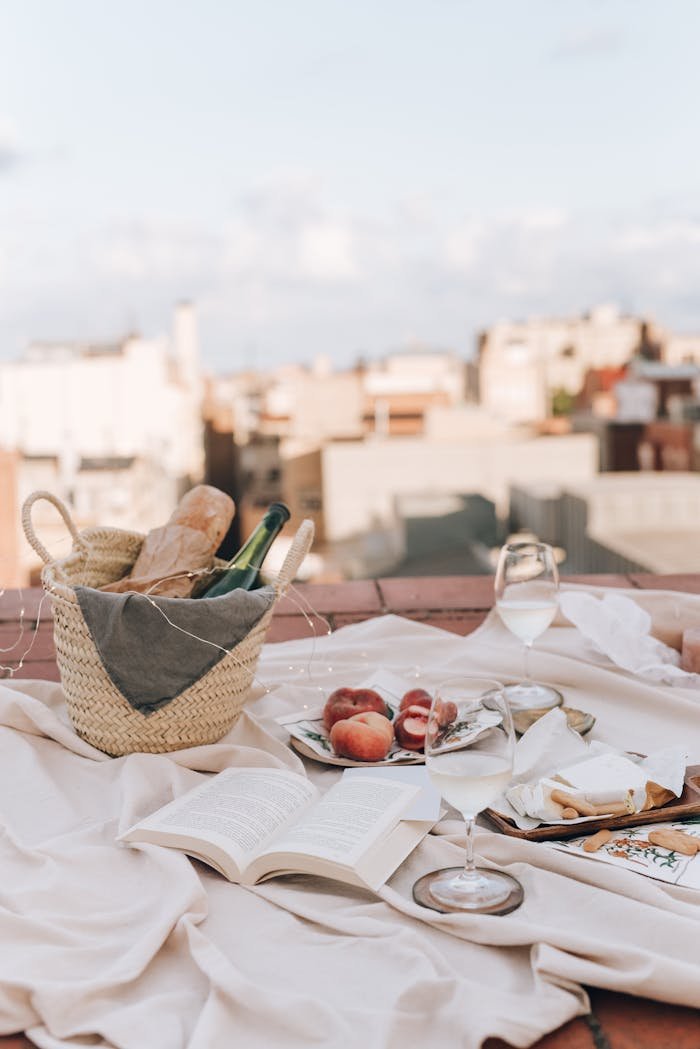our-services-01 A serene rooftop picnic scene with a basket, baguette, wine, and peaches.